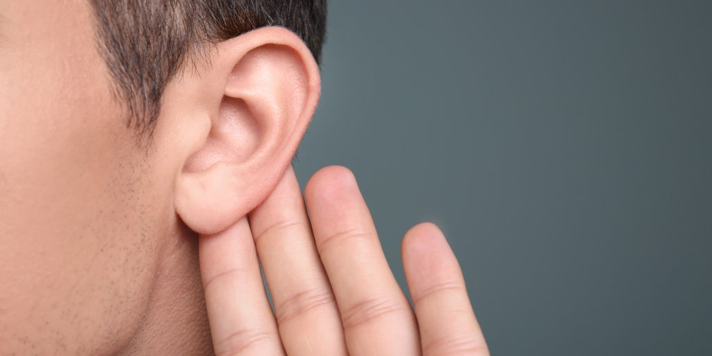 Man with hearing problem on grey background, closeup