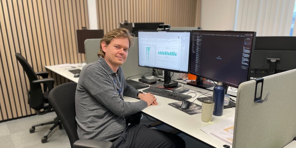 Bilde av Even som er intervjuet. Her sitter han foran pcen sin og jobber med Power BI. 