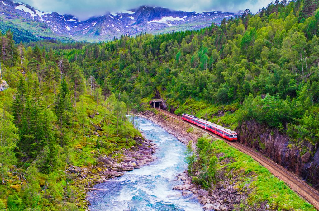 Tog som kjører i vakker natur i Norge