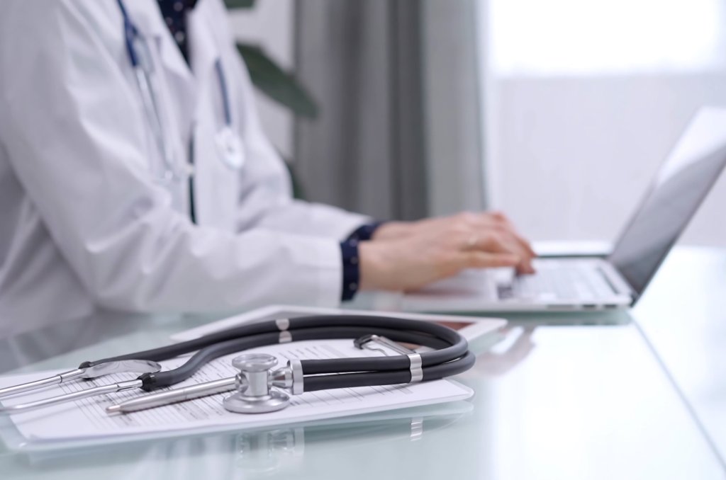 Bilde av en lege som bruker en PC