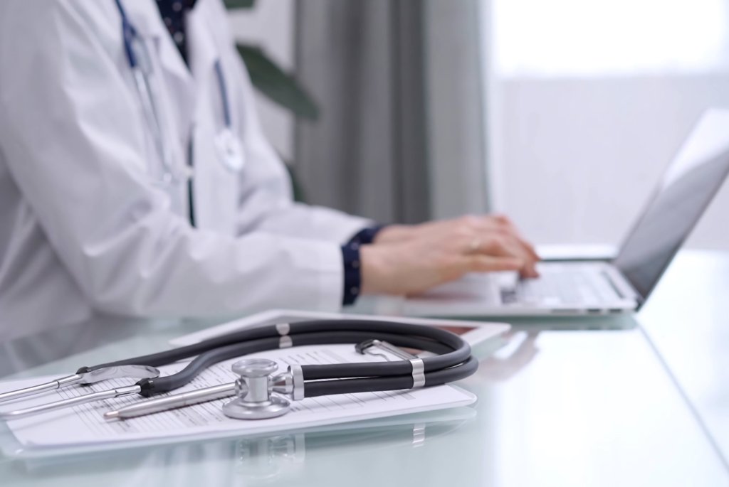 Bilde av en lege som bruker en PC