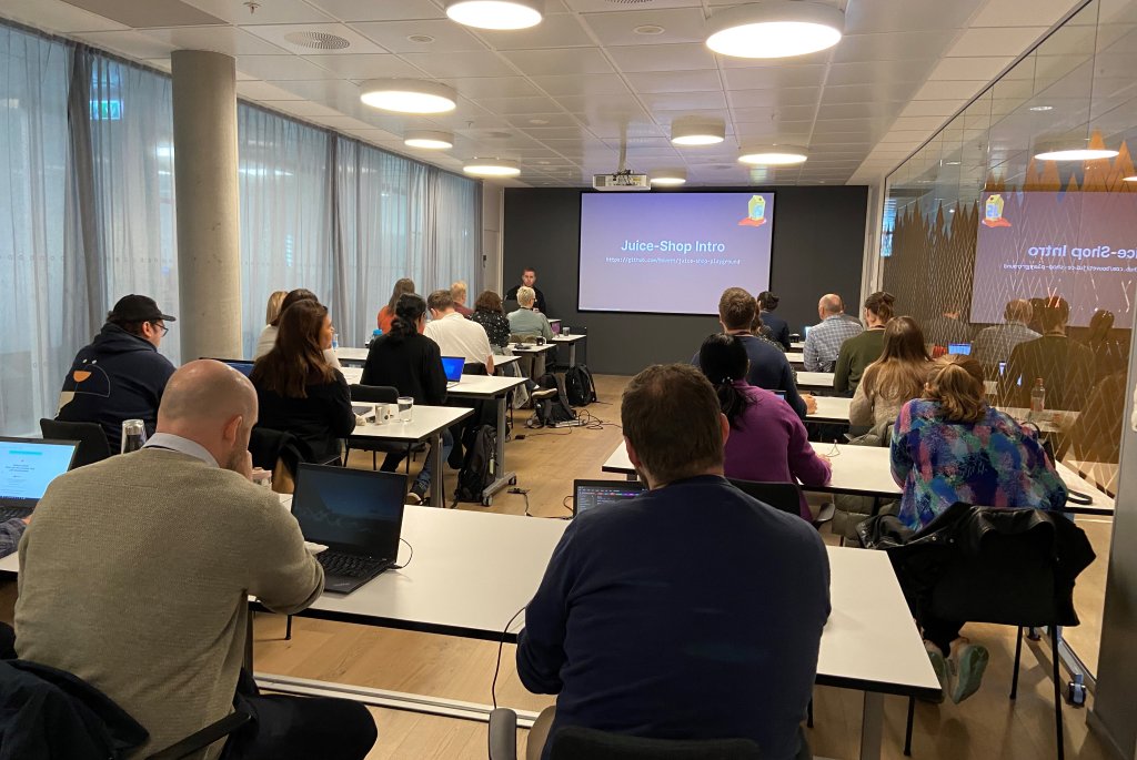 Bilde av fullt klasserommet med QA-deltakere fra workshopen, her lærer de om "juice shop" . 