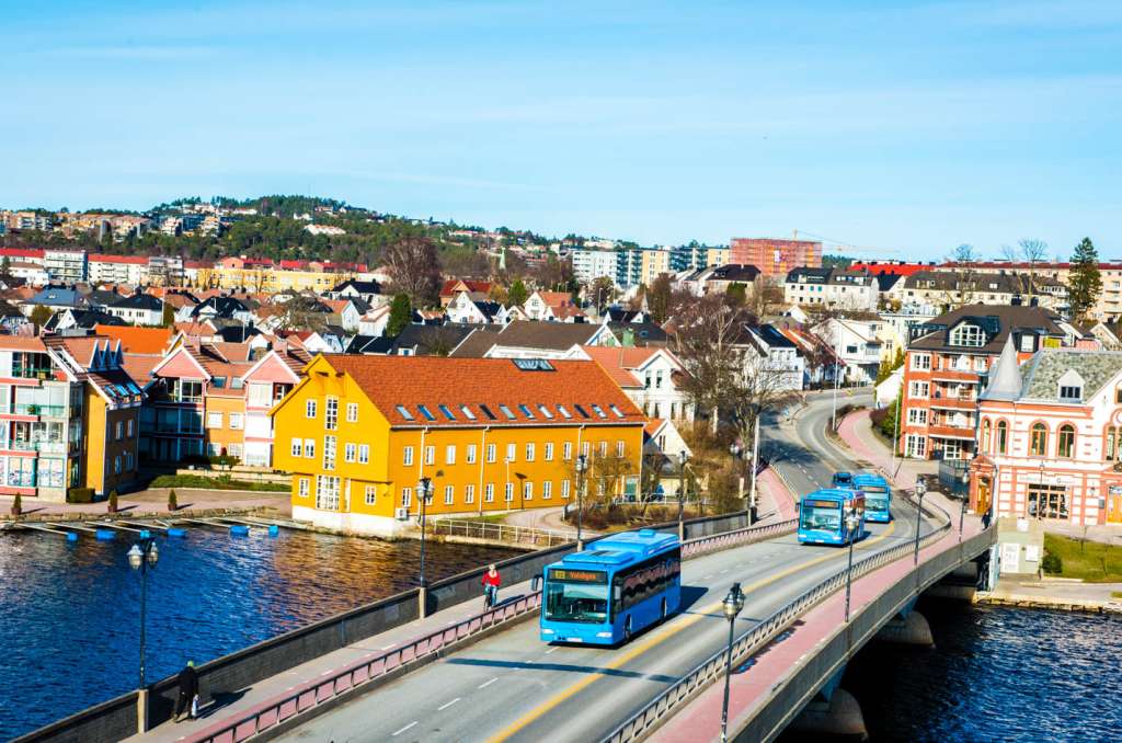 Tre blå busser kjører over en bro i Kristiansand