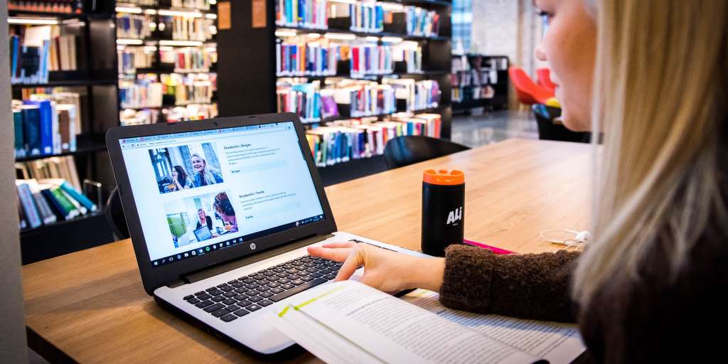 Jente ser på nettsiden inne på biblioteket på skolen
