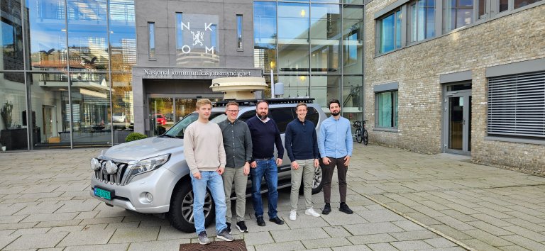 Bilde av teamet fra Bouvet som har jobbet sammen med Nkom i utviklingen av Signalutforskeren. De står foran kontoret til NKOM.