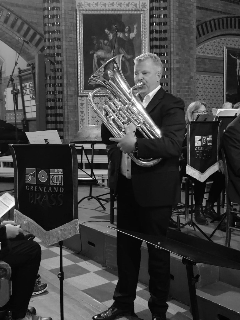 Foto av Bjørn Erik som spiller Euphorium på konsert i en kirke