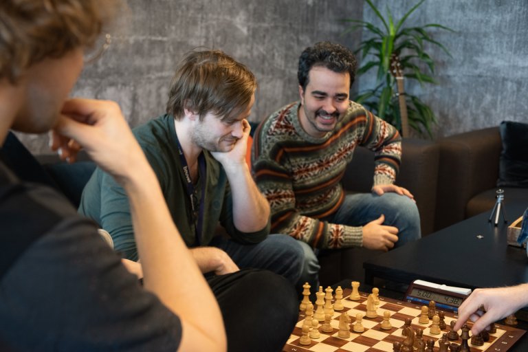 Bilde av Ali og kolleger som spiller sjakk i en pause på kontoret.
