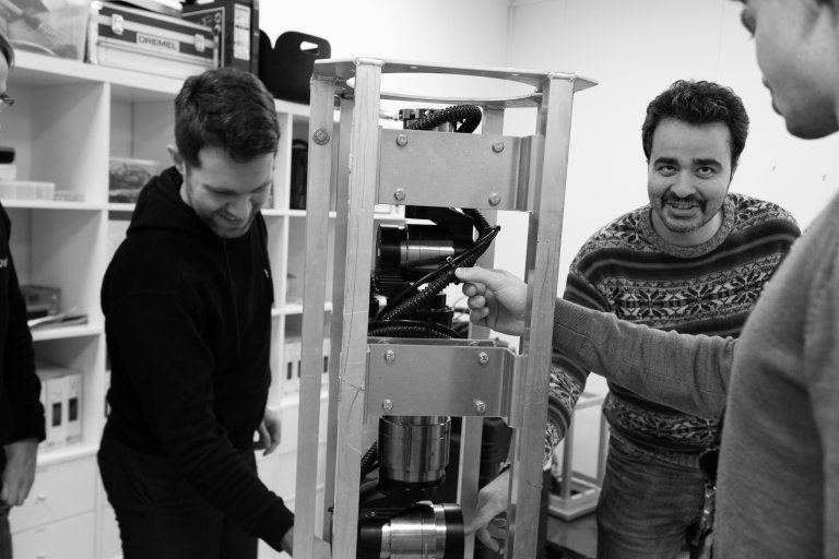 Ali jobber med en robot sammen med en kollega